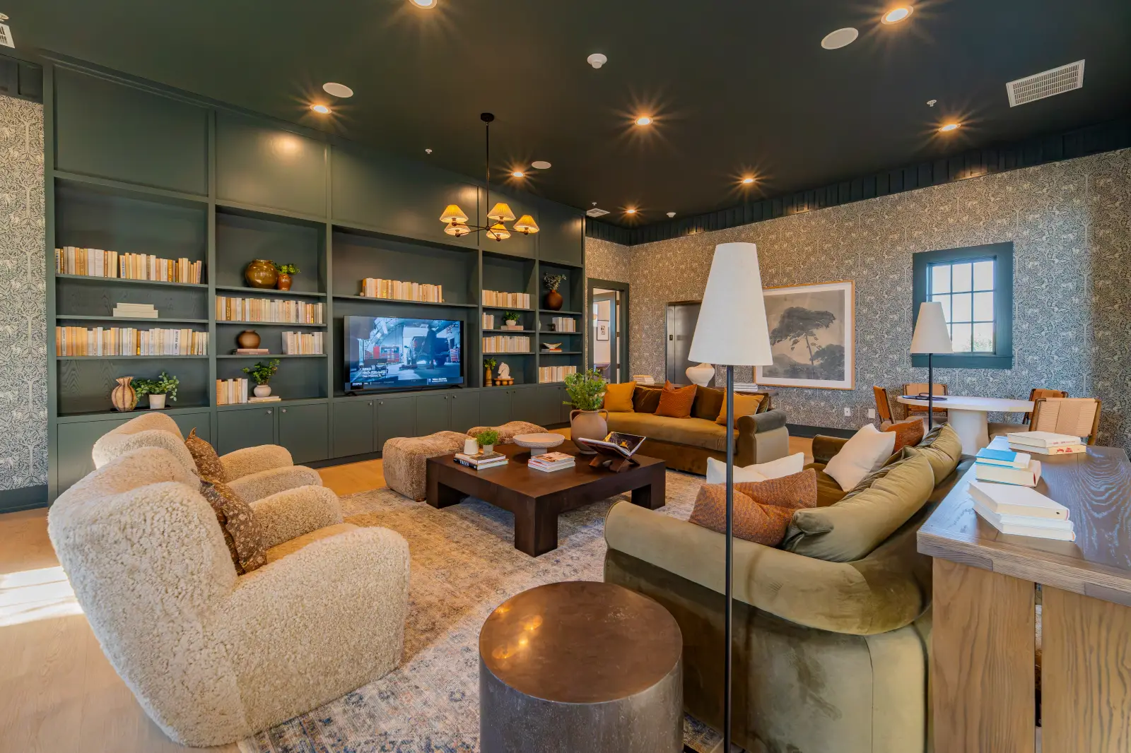 DSC02904 Clubhouse lounge with sofas, armchairs, built-in shelving, and a wall-mounted television