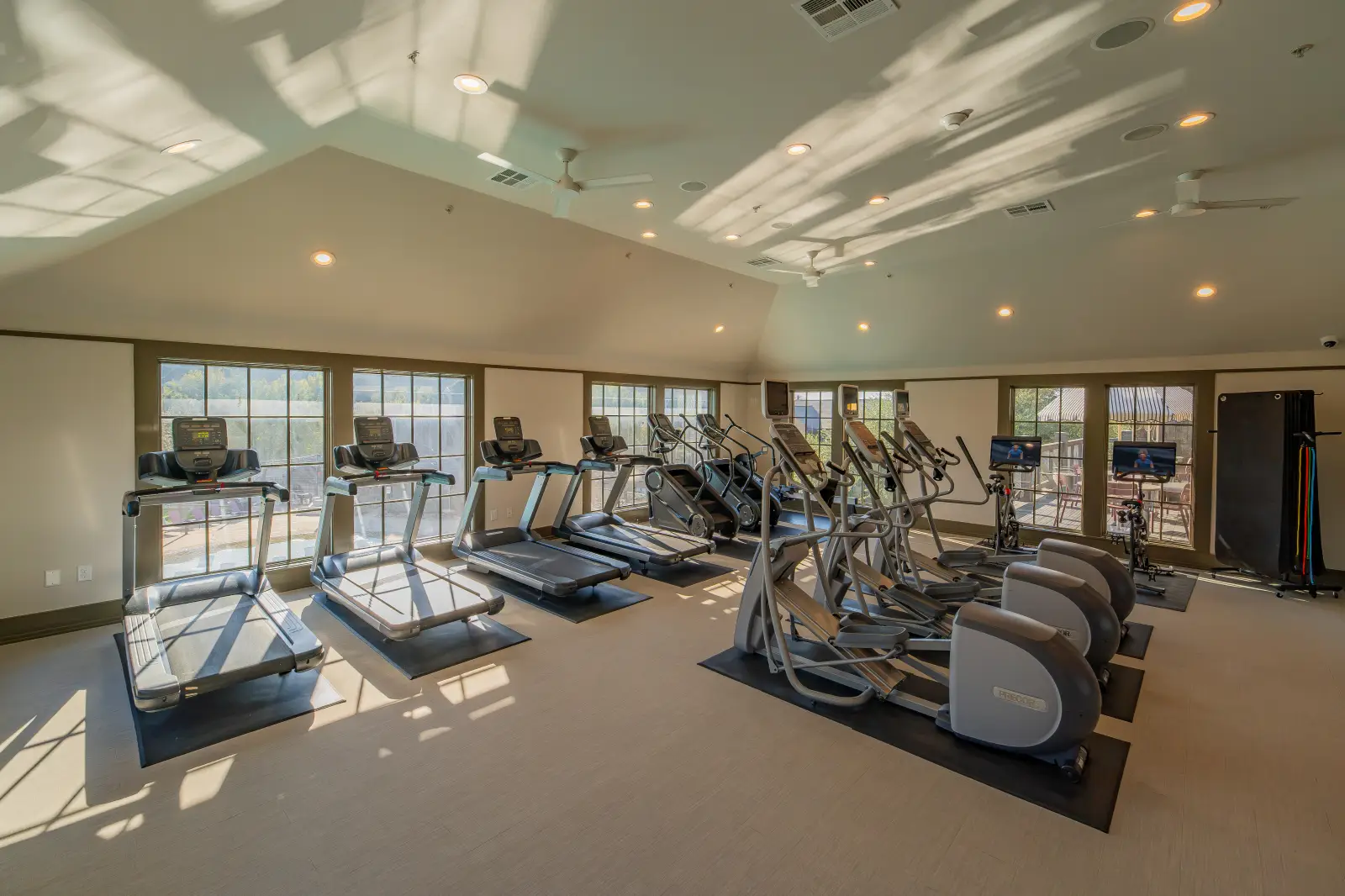 DSC02928 Bright fitness center with treadmills, elliptical machines, stationary bikes, and large windows