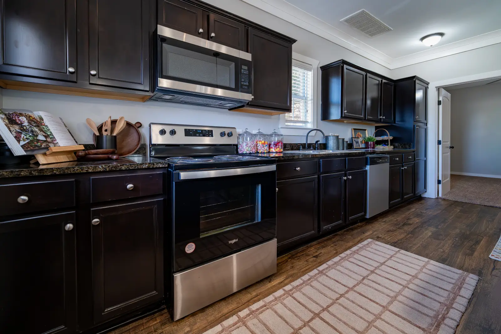 DSC04039 Dark wood kitchen with granite counters, stainless steel appliances, and plank flooring